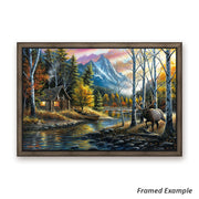 Framed canvas print of 'Living the Dream' with a wandering bull elk, dramatic mountain backdrop, and rustic cabin