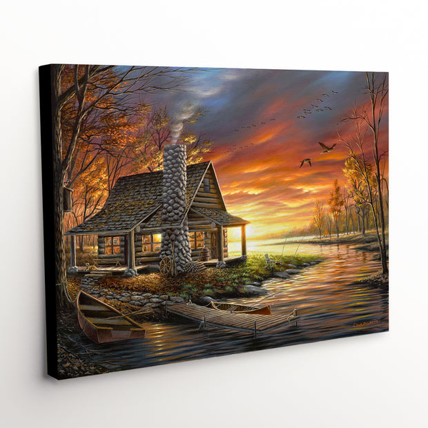 'The Perfect Spot' canvas art print portraying a picturesque cabin beside a glowing sunset lake, ideal for rustic decor enthusiasts